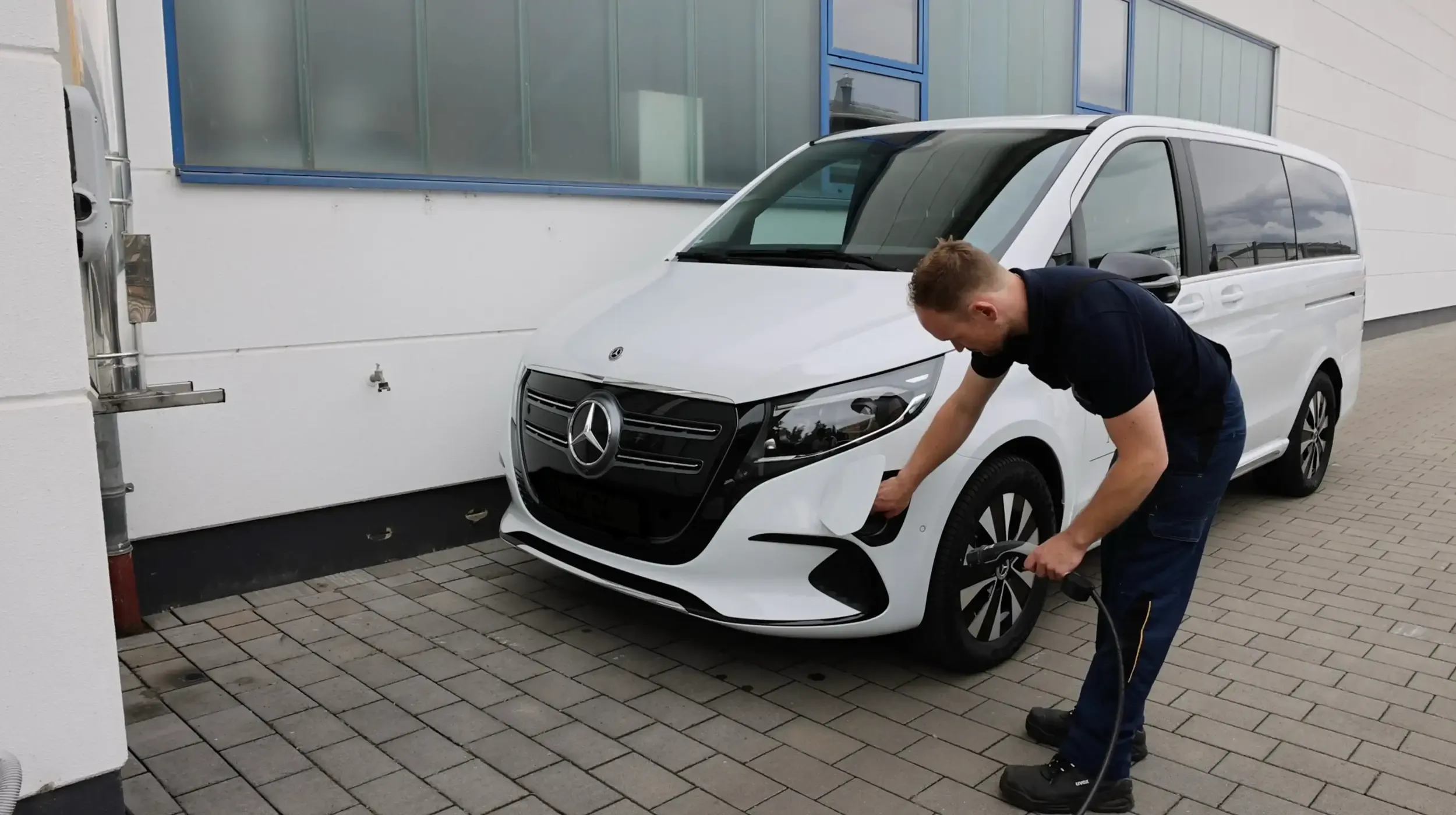 Mechaniker lädt Elektroauto auf