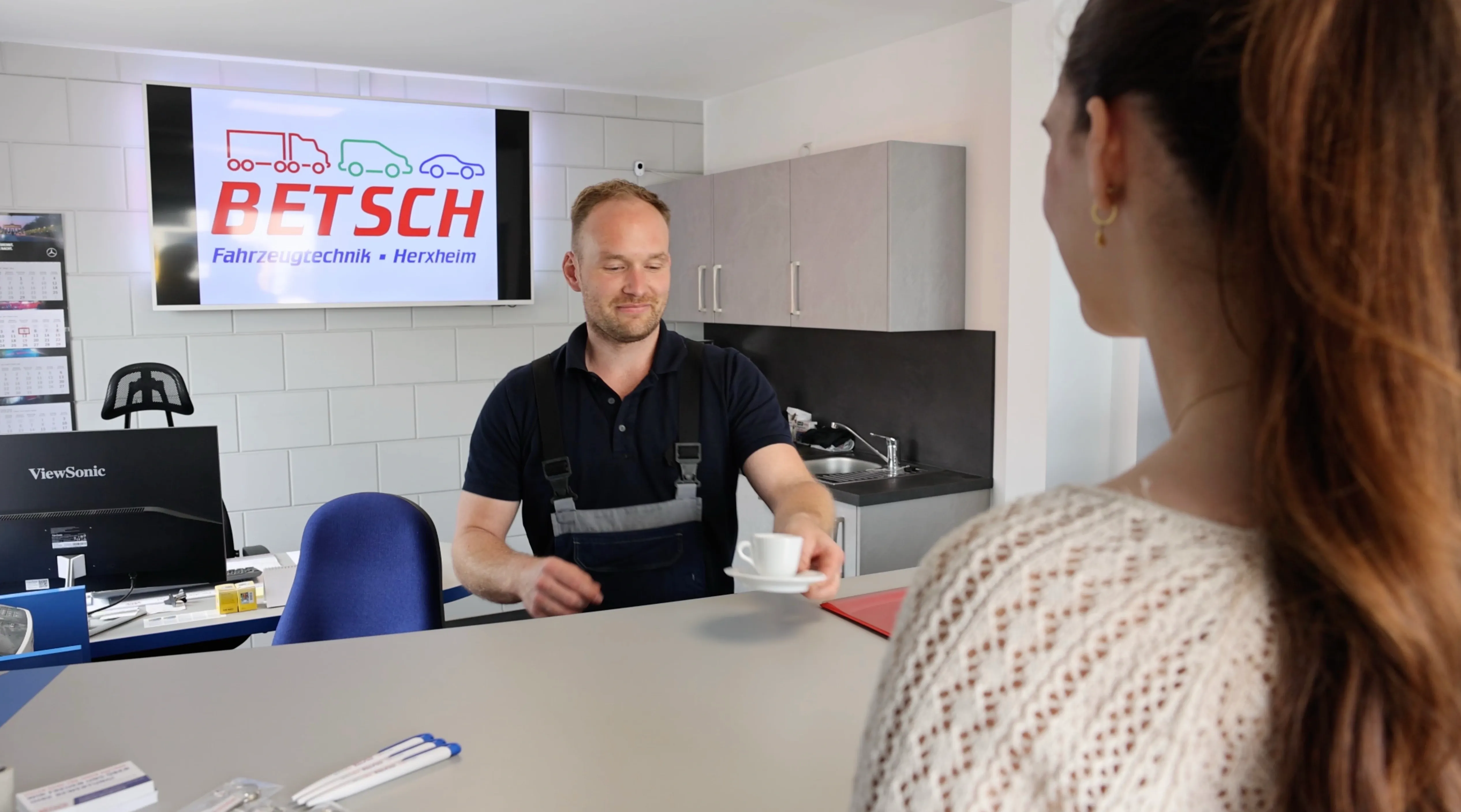 Ein Mann gibt einem Kunden die Schlüssel zur Autovermietung