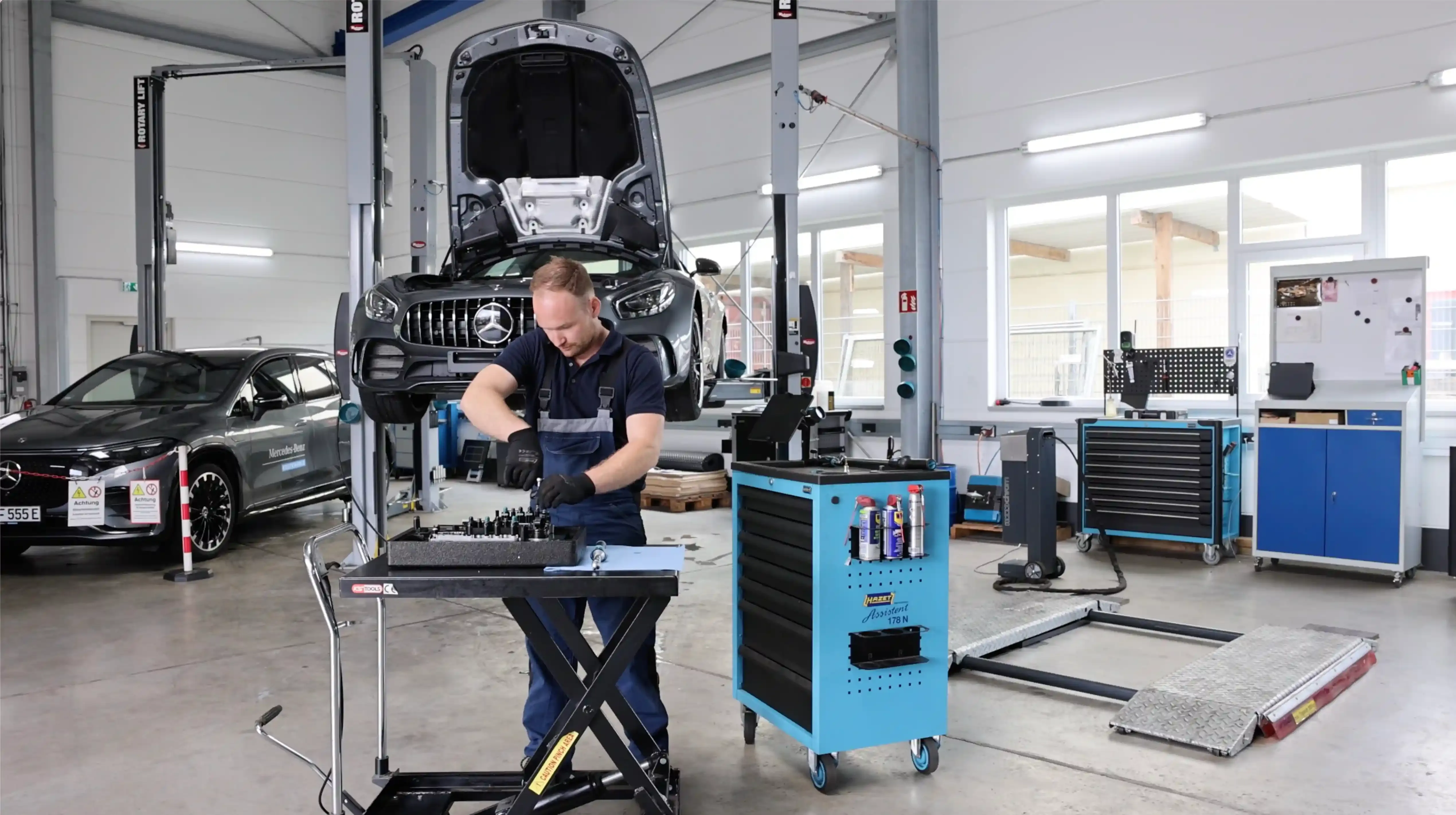 Mechaniker arbeitet an offener Motorhaube in Betsch Werkstatt